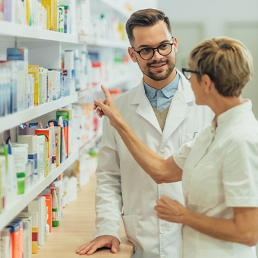 Twee apothekers overleggen bij medicijnen kast