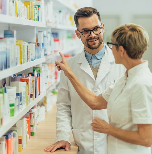 Twee apothekers overleggen bij medicijnen kast