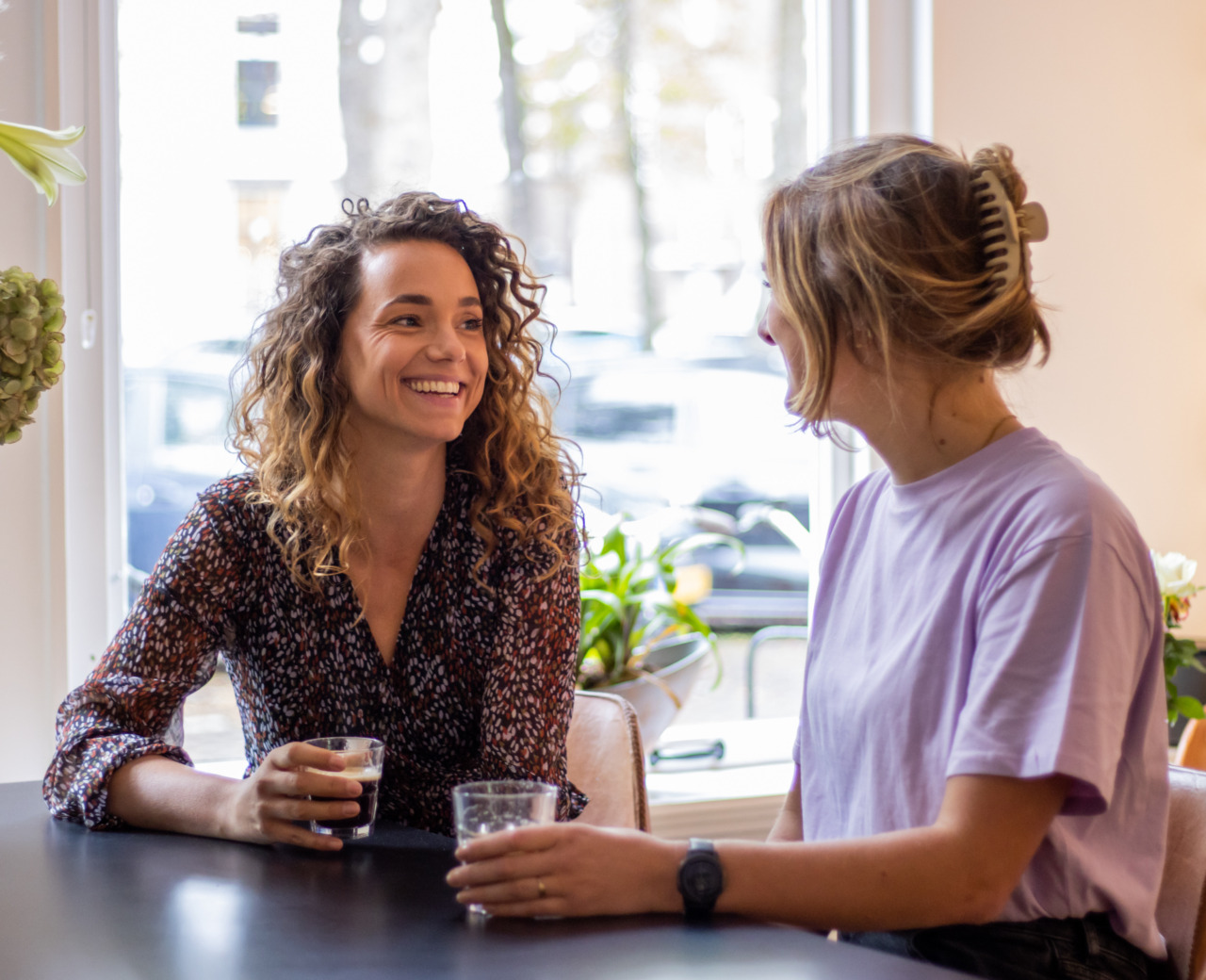 Twee vrouwen praten aan de bar met koffie