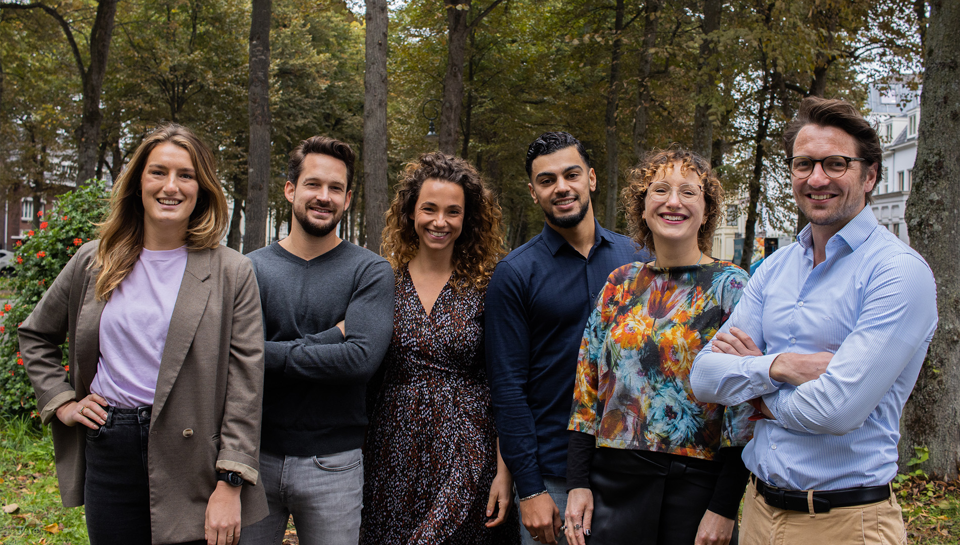 Groep mensen staat lachend buiten