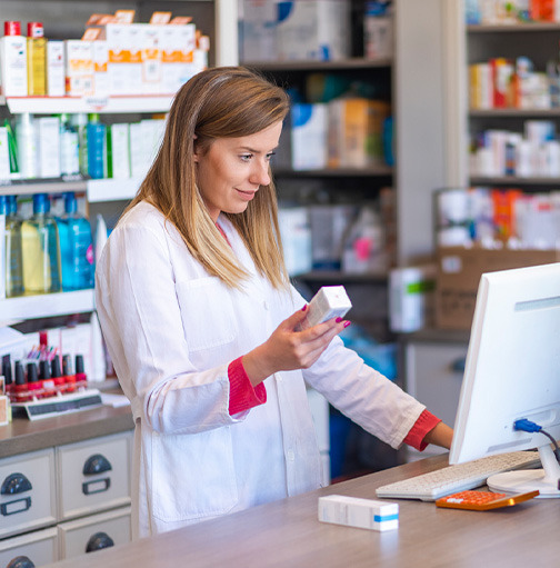 Apotheker bekijkt recept achter computer