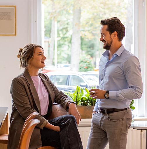 Man en vrouw kletsen op kantoor