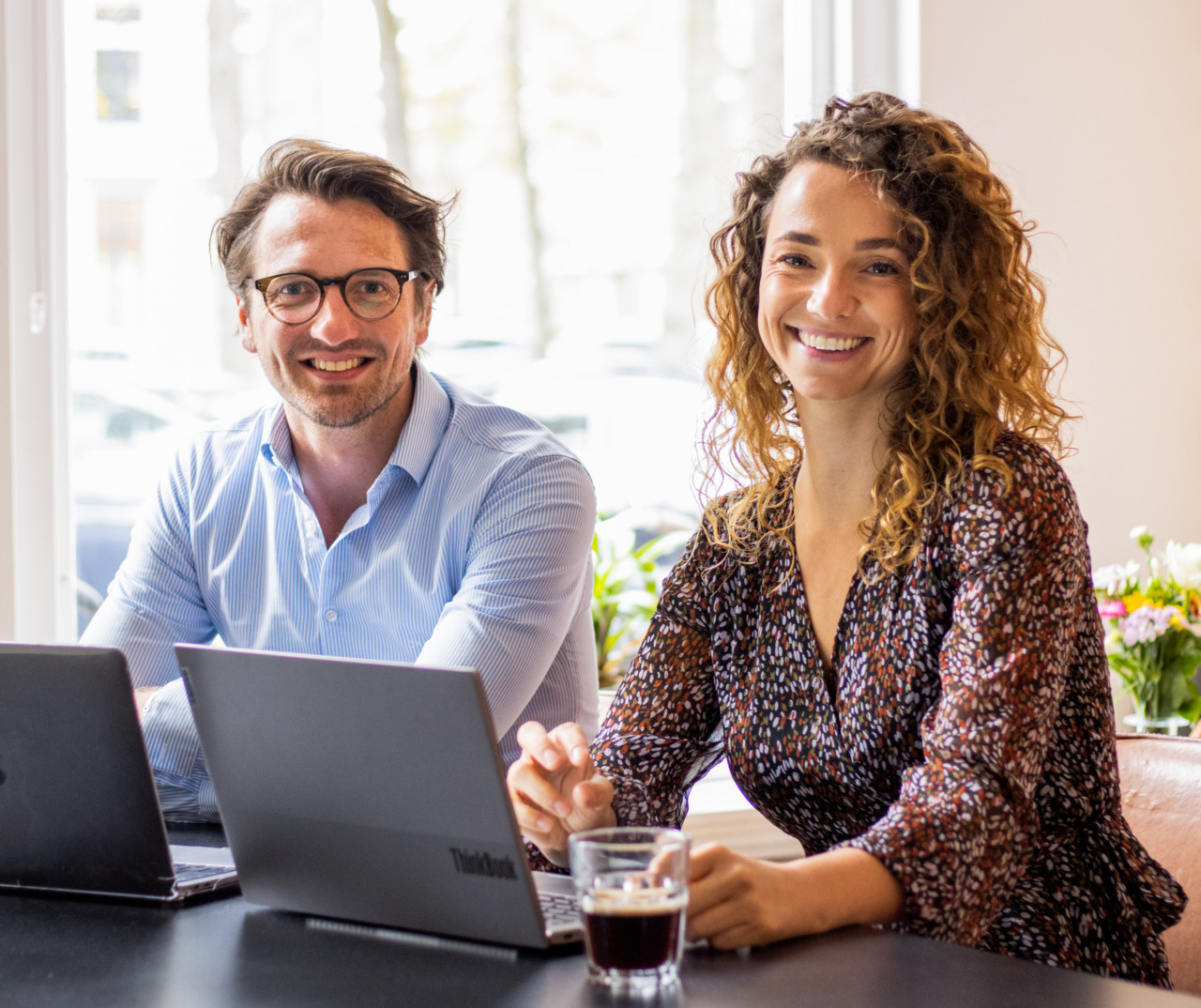 Twee collega's samen aan het werk achter een bureau